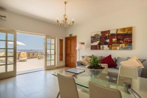a living room with a glass table and a couch at Valletta Penthouse in Valletta