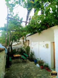 an outdoor patio with a table and a bench at Bed & Breakfast JOSIPH in Berat