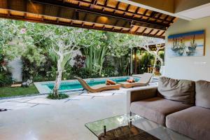 a living room with a couch and a pool at Desa Di Bali Villas in Kerobokan