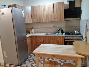 a kitchen with a stainless steel refrigerator and a table at Noclegi u Celiny i józefa in Łapszanka