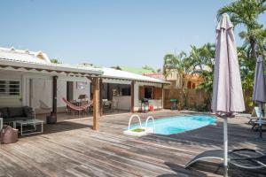 a deck with a hammock and a swimming pool at Villa Cosy - Grande capacité avec piscine in Le Gosier