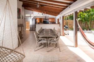 a dining room with a table and chairs on a patio at Villa Cosy - Grande capacité avec piscine in Le Gosier