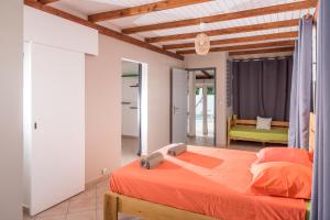 - une chambre avec un lit orange dans l'établissement Villa Cosy - Grande capacité avec piscine, au Gosier 42 autres photos