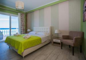 a bedroom with a bed and a chair and a window at Laura Beach House in Alykes