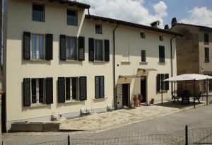 CasteggioにあるElicrisoの白い建物(黒いシャッター付きの窓、テーブル付)