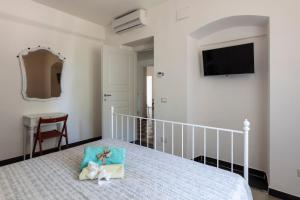 a bedroom with a bed with a pillow and a television at La BRIGNA B&B Il bosco sul mare in Genoa
