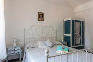 a bedroom with a white bed and a dresser at La BRIGNA B&B Il bosco sul mare in Genoa