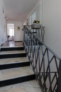 a staircase with a metal railing in a house at La BRIGNA B&B Il bosco sul mare in Genoa