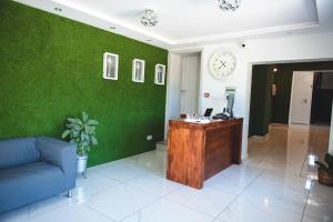 a living room with a desk and a green wall at Leon's Rooms in Żary