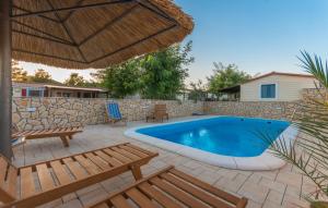 a backyard with a swimming pool and a stone wall at Camp Lana in Drage