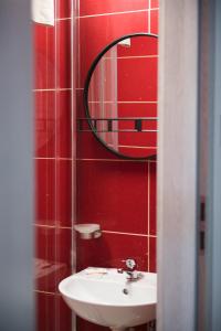 a bathroom with a sink and a mirror at Leon's Rooms in Żary