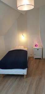 a bedroom with a black and white bed and a table at Gite Renaissance in Amboise