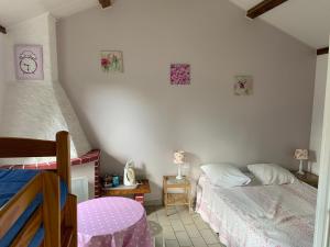 1 dormitorio con 2 camas y reloj en la pared en Auberge du Mont Tortue, en Champclause