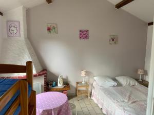 a bedroom with two beds and a clock on the wall at Auberge du Mont Tortue in Champclause