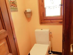 ein weißes WC im Bad mit Fenster in der Unterkunft Chalet Génépi in Montriond + 37 Fotos