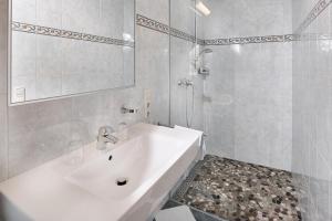 a white bathroom with a sink and a mirror at Haus Obermühle in Maria Alm am Steinernen Meer +33 photos