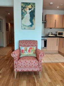 a living room with a chair with a painting on the wall at Almanna, Central York, only 6 minutes walk to York Minster in York