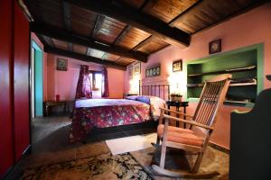 1 dormitorio con cama y silla de madera en La casa delle rose, en Otricoli