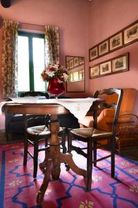una sala de estar con una mesa con un jarrón de flores. en La casa delle rose, en Otricoli