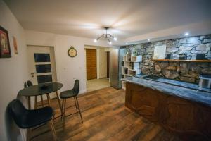 a kitchen with a bar with a stone wall at Villa Vida in Zmijavci