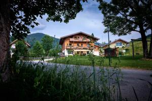 a large wooden house on the side of a road at Haus Obermühle in Maria Alm am Steinernen Meer