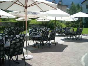 un grupo de mesas y sillas con sombrillas en Hotel Danis, en Lenzerheide