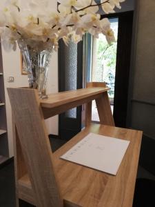 una mesa con un jarrón de flores encima en La Tana Rooms en Lenno