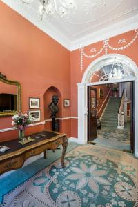 una sala de estar con paredes de color naranja y una escalera. en Harrington Hall en Dublín