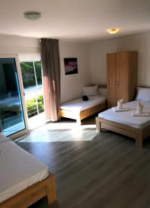 a hotel room with two beds and a window at Rosi`s Apartment in Sutomore +40 photos
