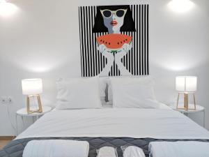 a bedroom with a bed with a painting of a woman holding a watermelon at Vivo Apartments in Athens