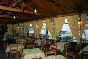 a restaurant with tables and chairs with a view of the water at PARADEISOS in Elliniká