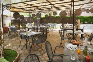 een restaurant met tafels en stoelen onder een tent bij Pont du Chalon Hôtel and Restaurant in Margès