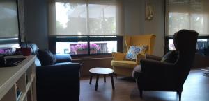 - un salon avec des chaises, une table et des fenêtres dans l'établissement Hotel Cachada, à Sanxenxo