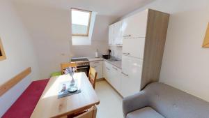 博希尼的住宿－Apartmaji pri Marodnu，一个带桌子和椅子的小厨房
