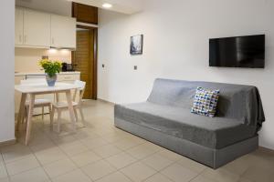 - un salon avec un canapé et une table dans l'établissement Forum City Apartments, à La Canée