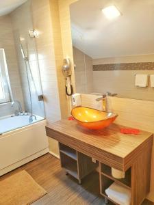 a bathroom with a bowl sink on a wooden counter at 5 Star Residence in Braşov +106 photos