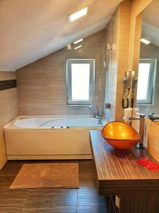 a bathroom with a tub and a bowl on a table at 5 Star Residence in Braşov