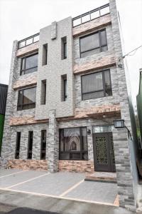 un edificio de ladrillo con una puerta delante en WT BnB Taichung en Houli