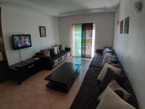 un soggiorno con un divano e una TV di Beautiful apartment at RIVIERA BEACH RESIDENCE CABO NEGRO a Cabo Negro