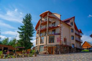 un grande edificio con un albero di fronte di Sadyba u Halyny a Bukovel