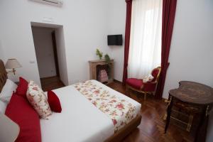 um quarto com uma cama, uma cadeira e uma janela em AD2015 Guest House em Roma