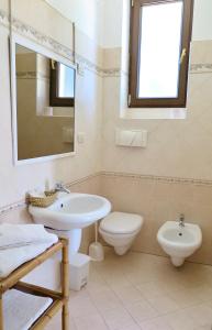 a white bathroom with a sink and a toilet at La Dimora di Ulisse in Santa Cesarea Terme