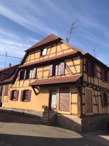 an old wooden house with shuttered windows on a street at GITE DES FORGERONS in Dambach-la-Ville