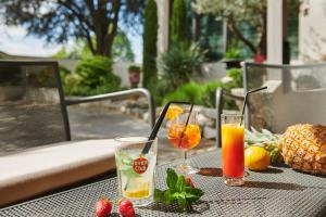 uma mesa com duas bebidas e fruta sobre ela em Pont du Chalon Hôtel and Restaurant em Margès