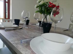 a wooden table with wine glasses and flowers on it at Cilento Relax City House in Montecorice