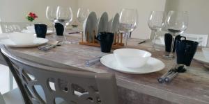 a table with plates and wine glasses on it at Cilento Relax City House in Montecorice