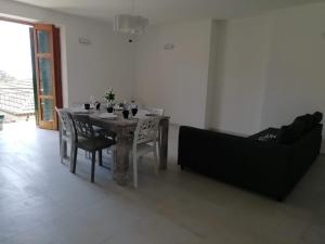 a dining room with a table and a couch at Cilento Relax City House in Montecorice
