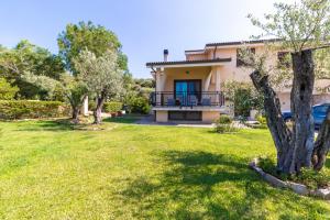 a house with a yard in front of it at Il giardino degli ulivi in Santa Maria Coghinas
