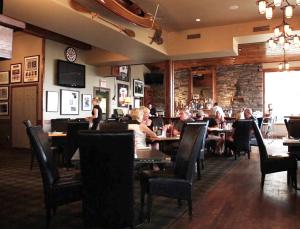 un grupo de personas sentadas en mesas en un restaurante en Oakwood Resort, en Grand Bend