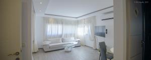 sala de estar con sofá blanco y ventana en Royal Lea Apartmens, en Netanya
